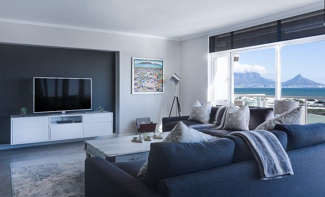 Foto de sala de apartamento com decoração colorida e vista para o mar.